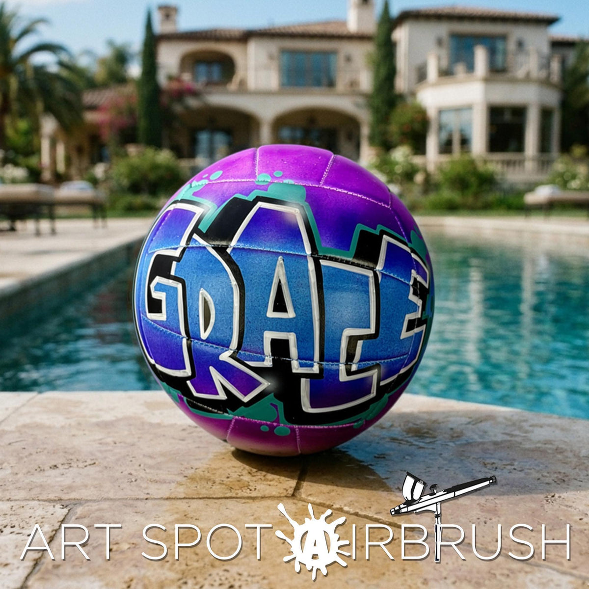 A purple and blue custom volleyball personalized with the word "GRACE" painted on it, sitting on a tiled surface near a swimming pool.