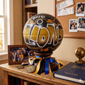 a trophy with the word "LIONS" written on it, placed on a wooden table. The trophy is surrounded by various items, including a framed photo, a medal, and a book.