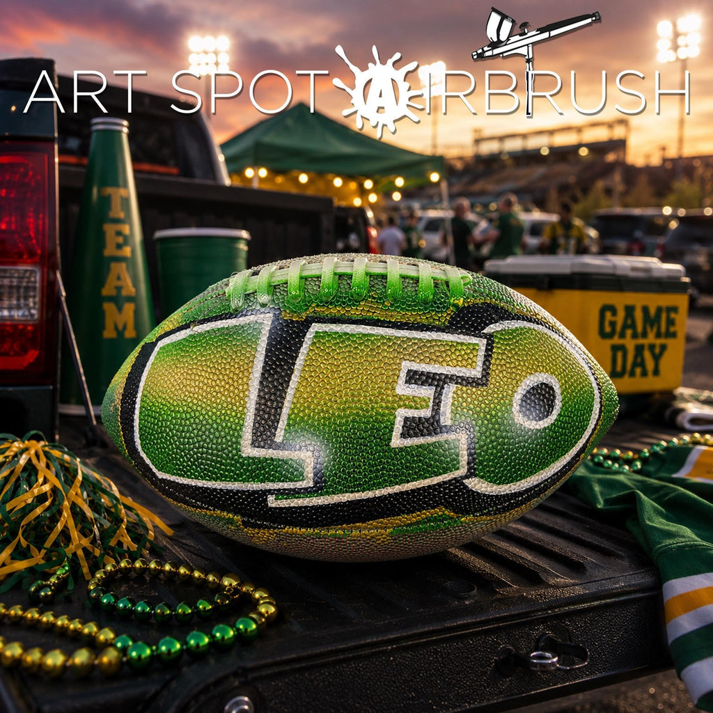 a green and black custom football personalized with the letters "LEO" on it, placed on a truck bed with various sports memorabilia, including a green cup, a yellow cooler, and a beaded necklace.