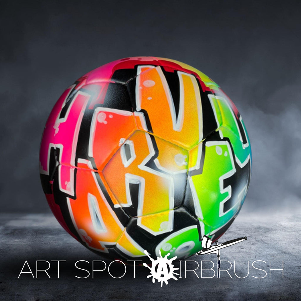 A colorful, graffiti-style soccer ball with the text "ART SPOT AIRBRUSH" written on it.