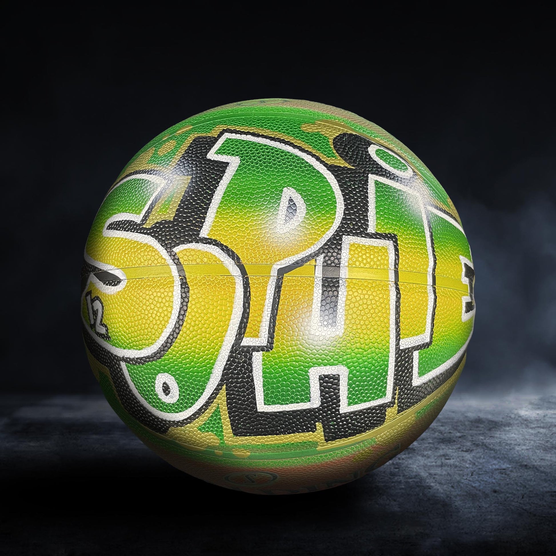 A colorful basketball with the word "SPIN" painted on it, set against a dark background.