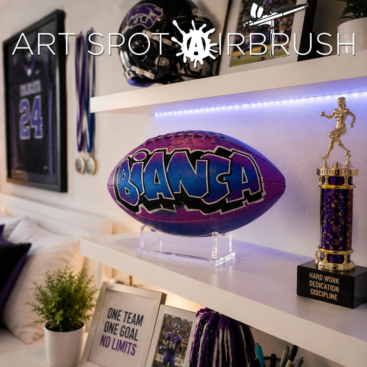 a sports-themed room with various sports memorabilia and awards displayed on shelves beside a custom football personalized with the name BIANCA