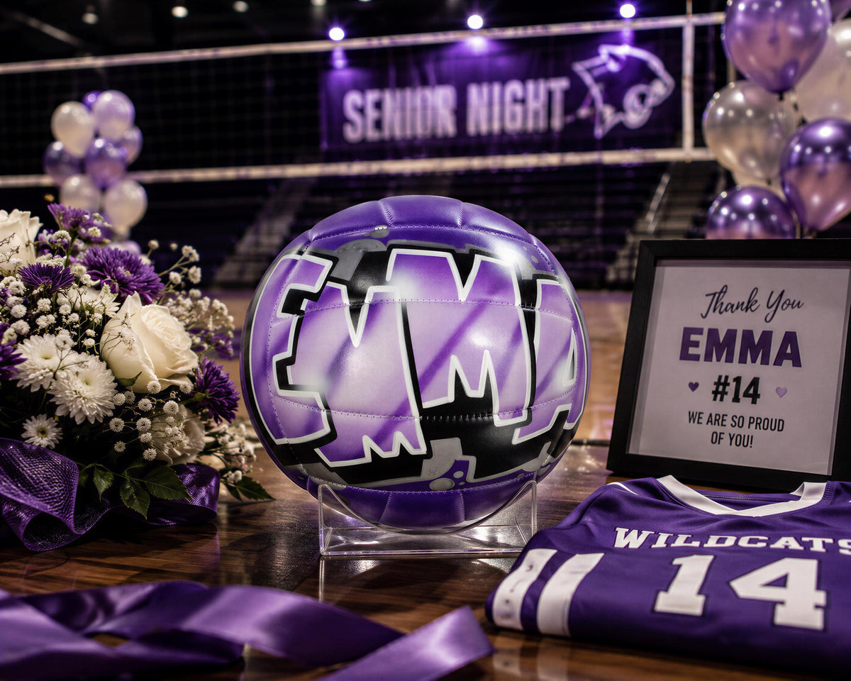 a purple volleyball with a purple and white design, a framed sign, a bouquet of flowers, and a purple jersey with the number 14.