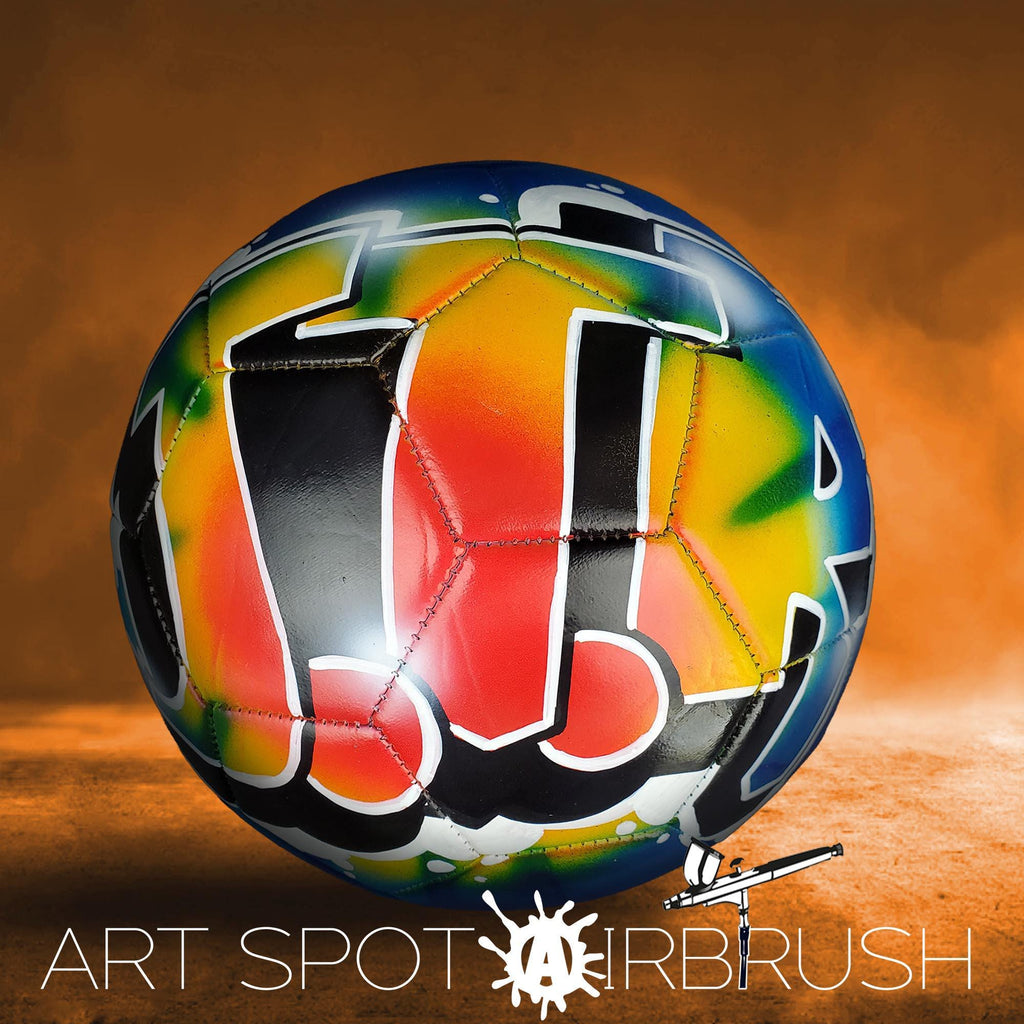 A colorful, graffiti-style soccer ball with a vibrant design on it, set against an orange background.