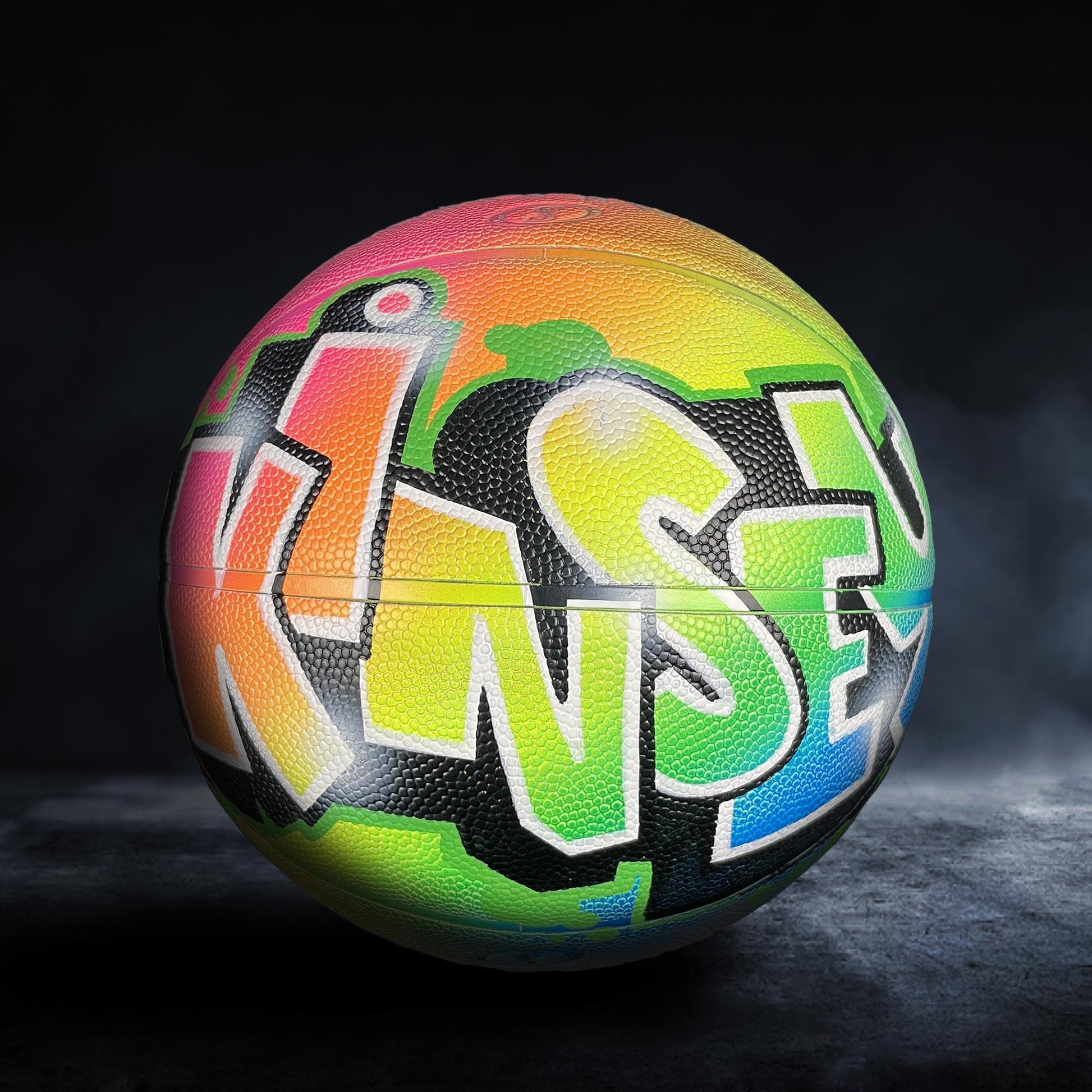 A colorful basketball with graffiti-style lettering on it.