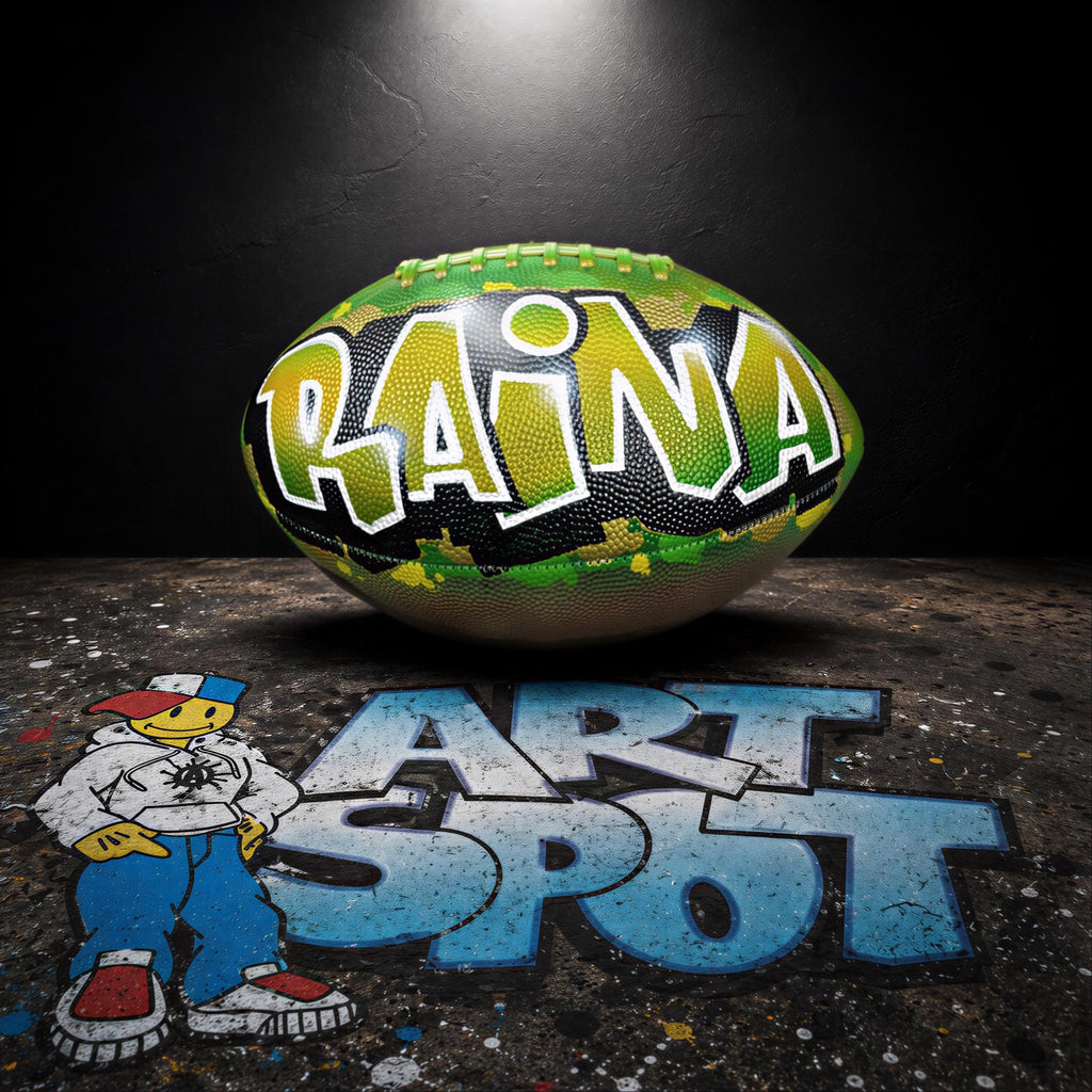 a colorful football with the name "RAINA" written on it, placed on a dark surface with graffiti-style text.