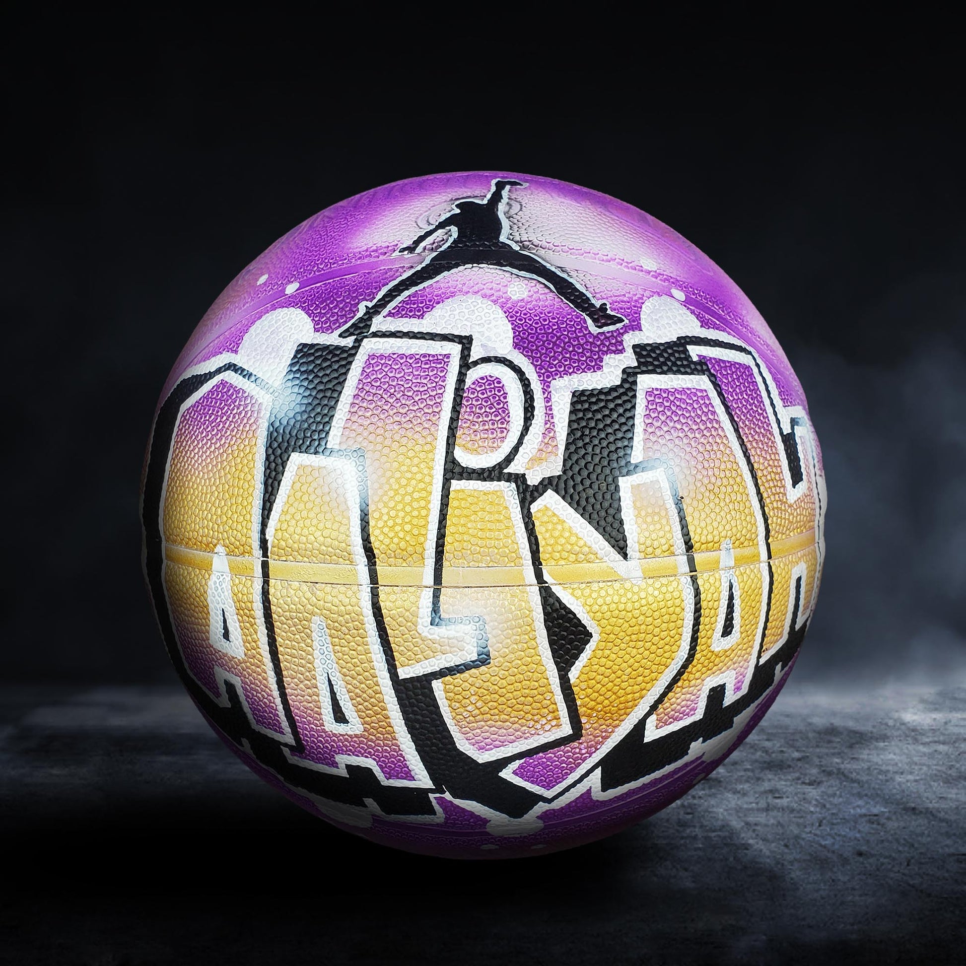 A basketball with a colorful, graffiti-style design on it, featuring the word "ALIYAH" prominently displayed.