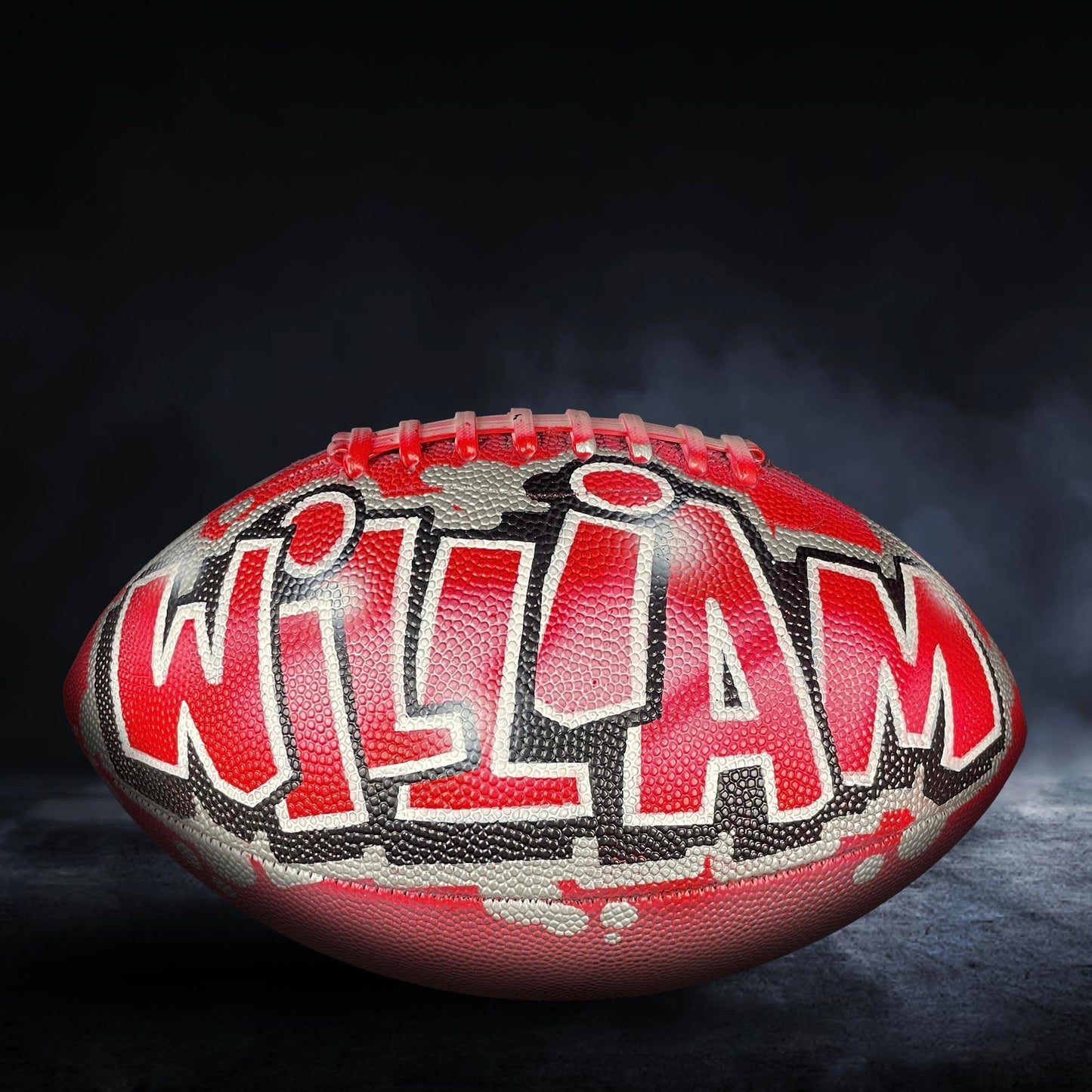 A red and black football with the name "William" written on it.