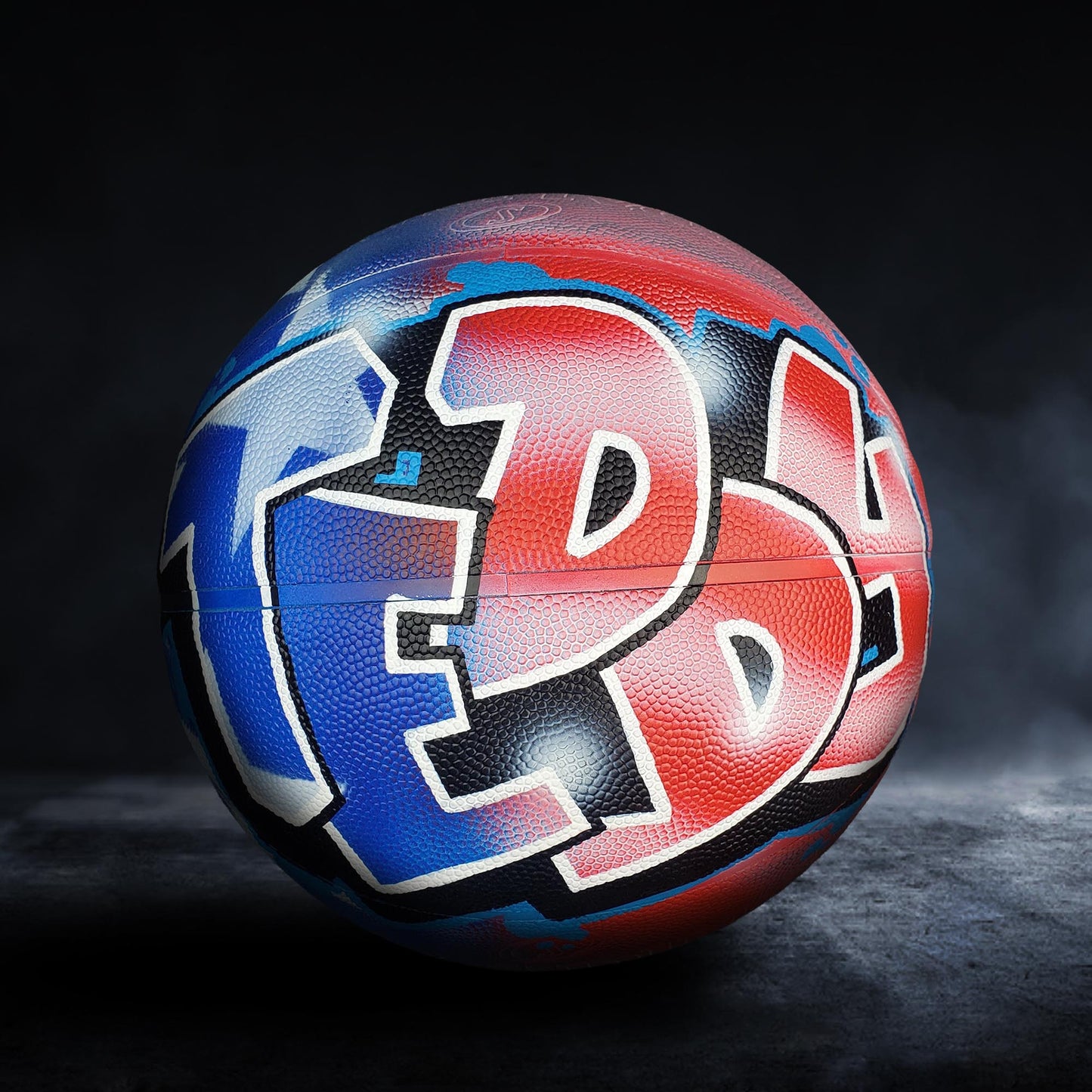 A basketball with a colorful graffiti design on it, featuring the letters "FED" in red, blue, and black colors.