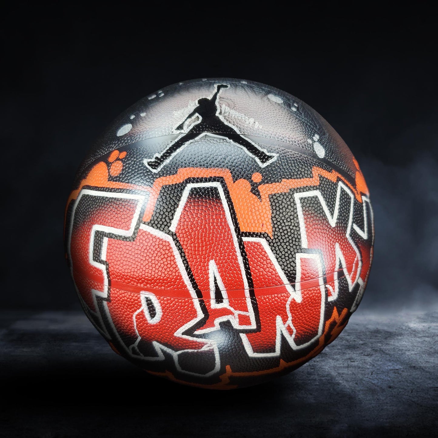 A basketball with graffiti art on it, featuring the word "FRANK" prominently displayed.