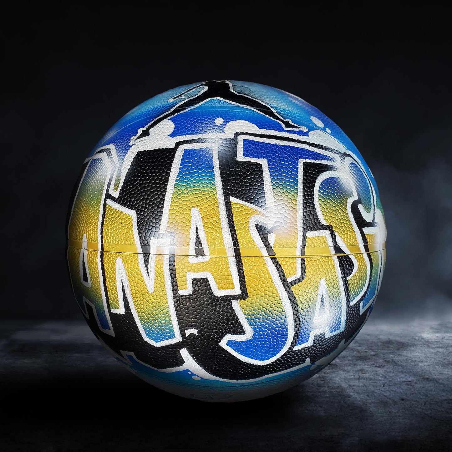 A basketball with the word "JAZZ" painted on it in a colorful, graffiti-style design.