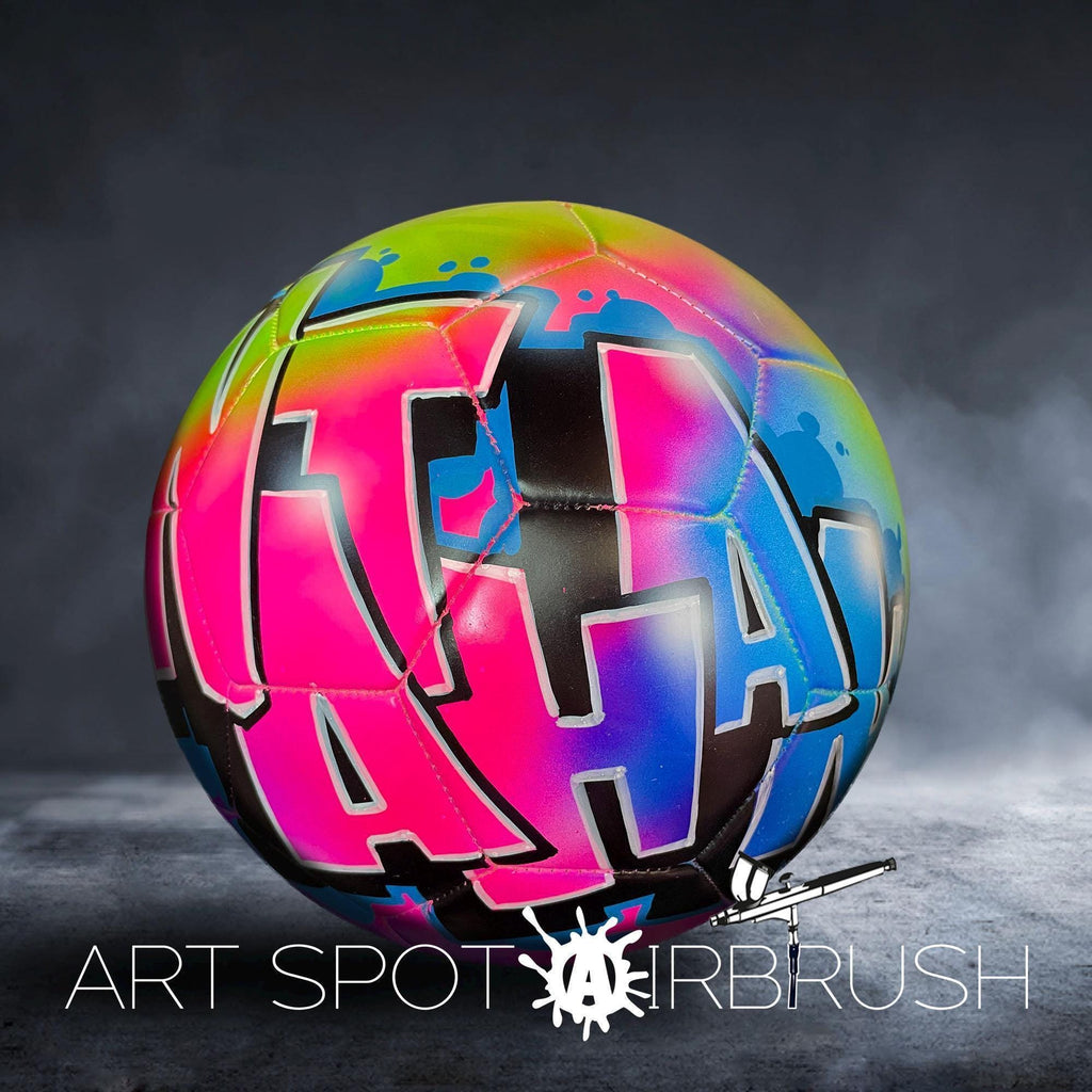 A colorful, graffiti-style soccer ball with the text "ART SPOT AIRBRUSH" displayed on it.