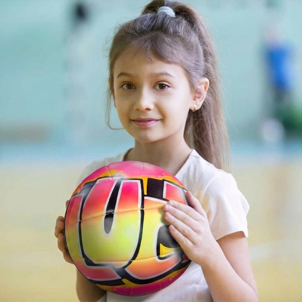 A young girl holding a colorful custom volleyball, smiling at the camera.