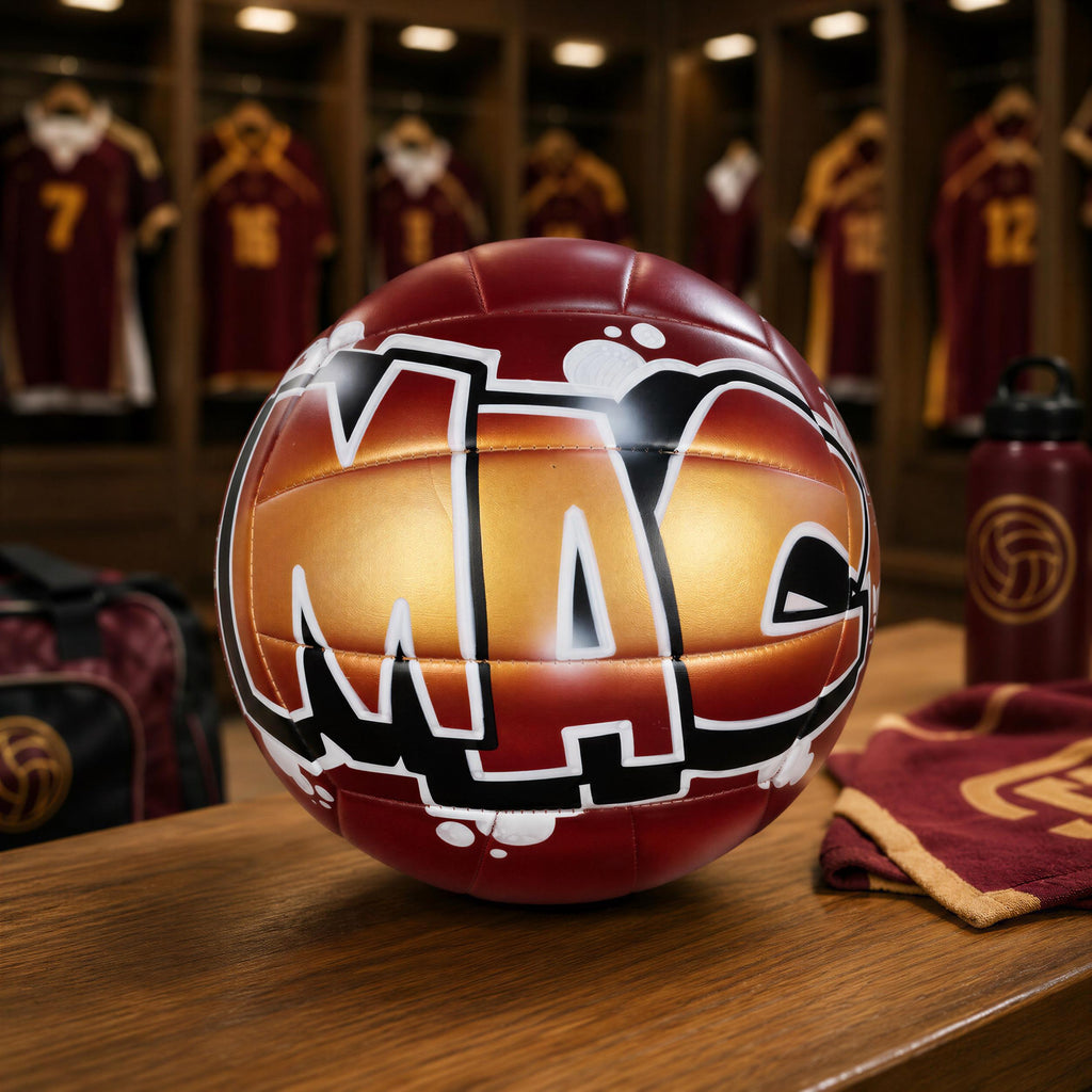 A red and gold volleyball with the letters "MAC" on it, surrounded by sports equipment and uniforms in a locker room setting.