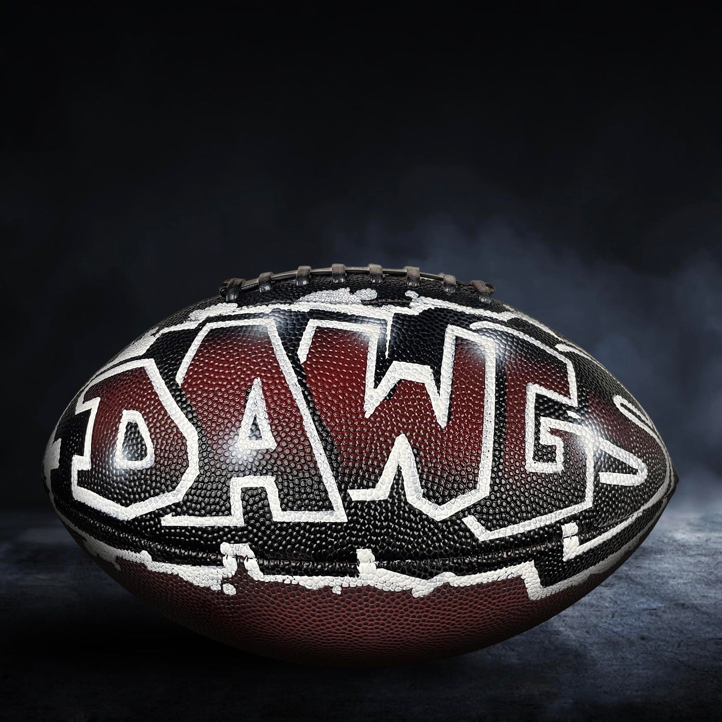 A football with the word "DRAG" written on it, against a dark background with smoke.