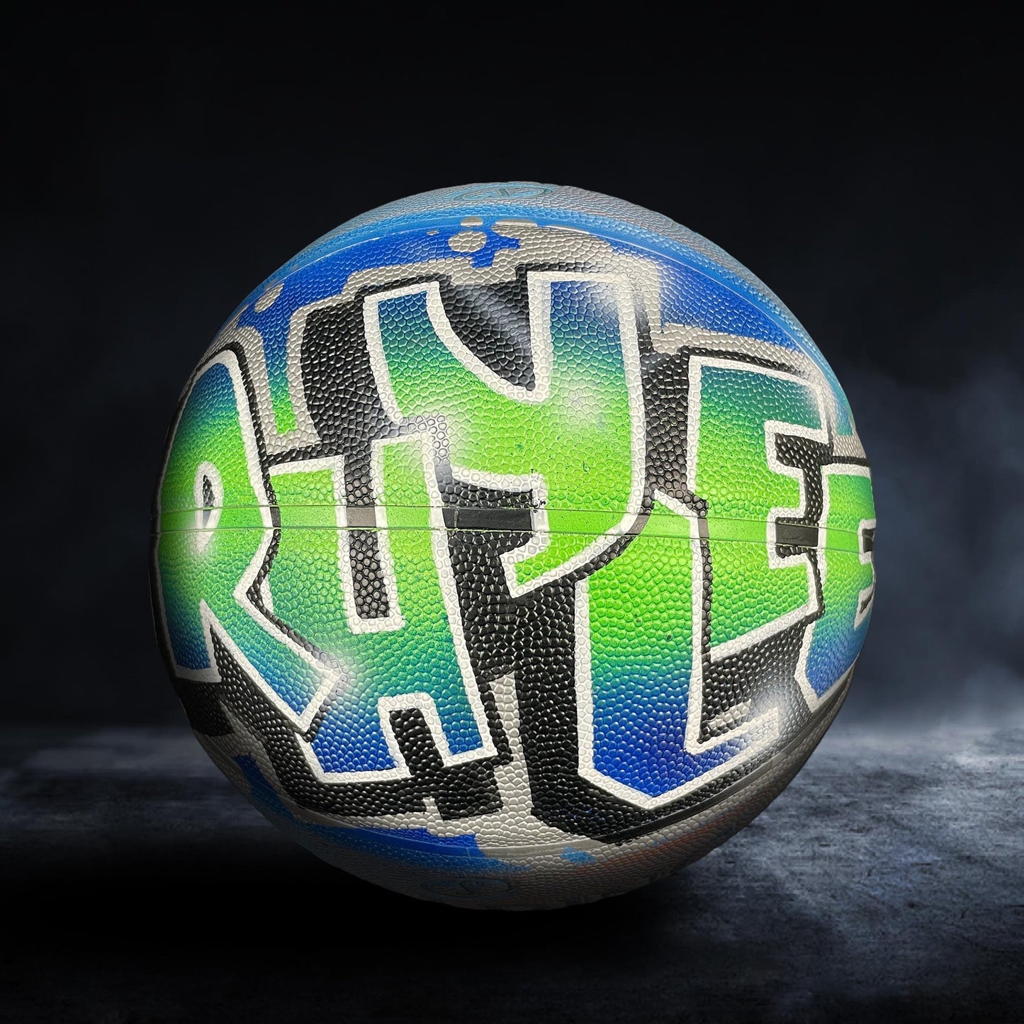 A basketball with the word "RAYS" painted on it in a colorful, graffiti-style design.