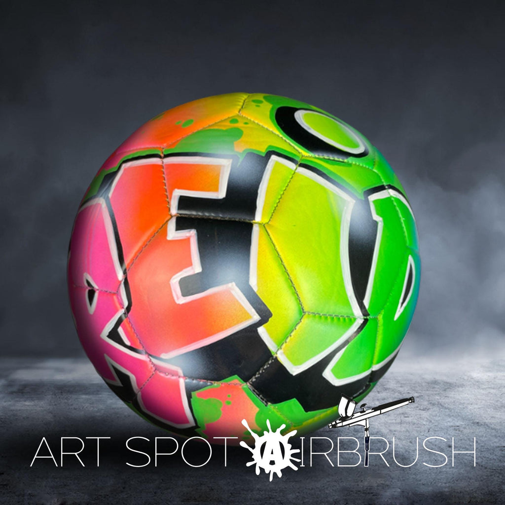 A colorful, graffiti-style soccer ball with the text "ART SPOT AIRBRUSH" displayed on it.