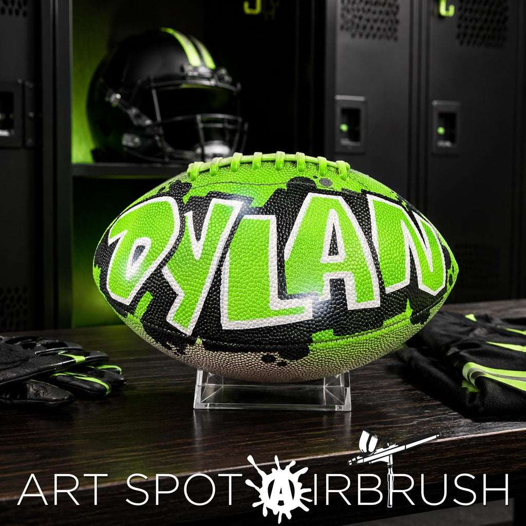 A neon green and black personalized custom football with the name "Dylan" written on it, displayed on a wooden surface in a locker room setting.