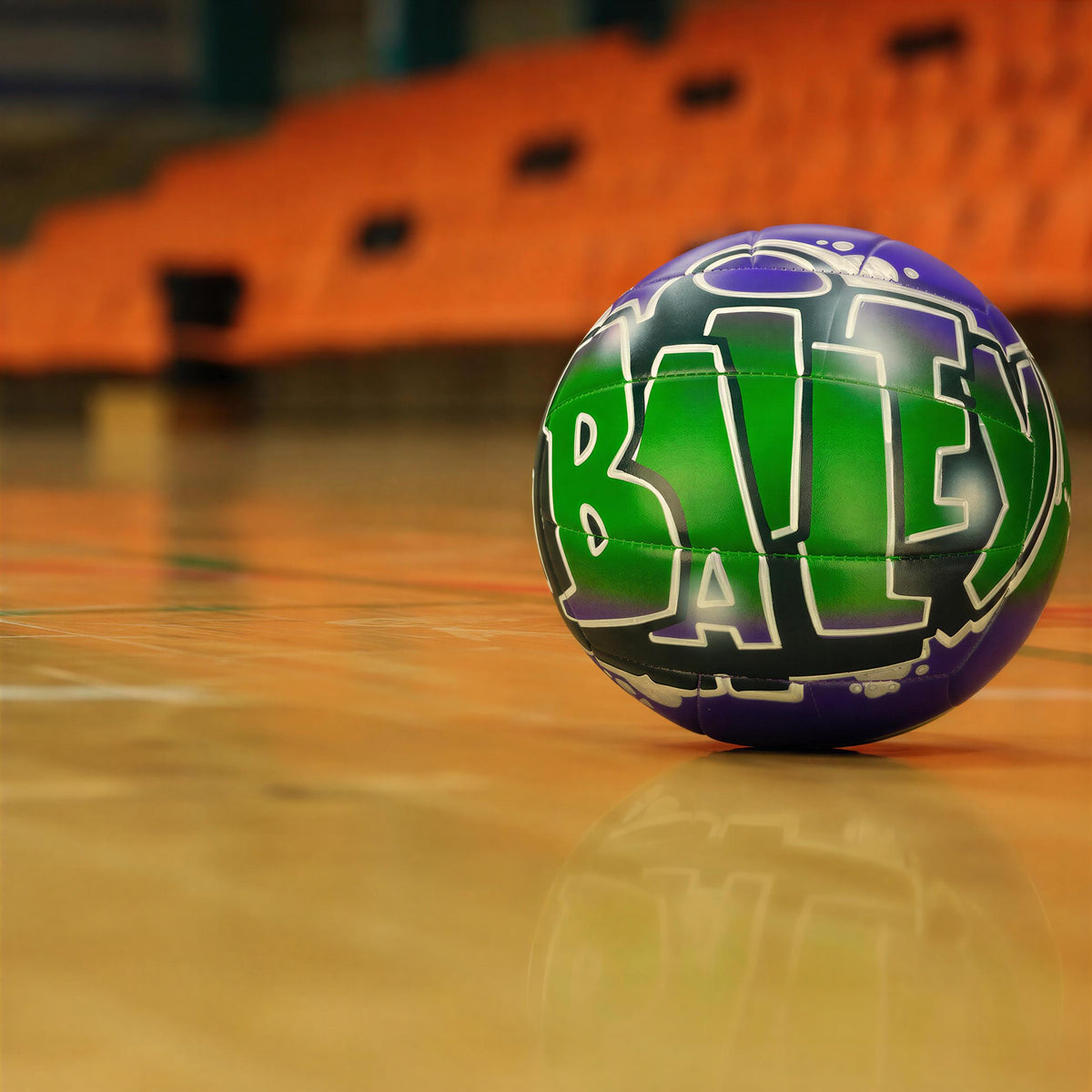 A green and purple sports ball with the word "BAL" written on it, placed on a basketball court.