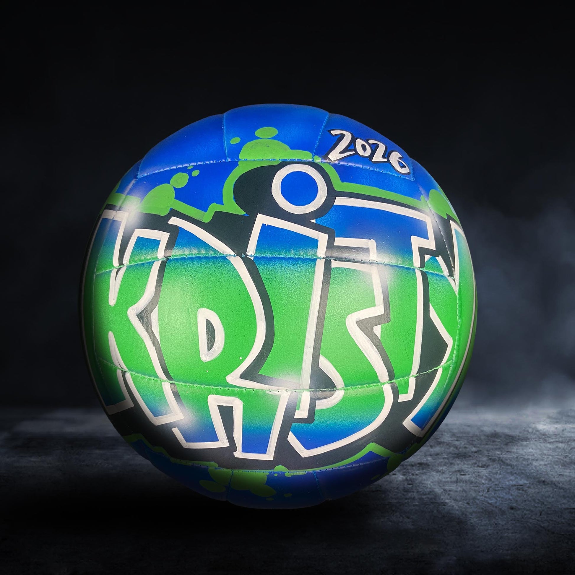 A colorful volleyball with the word "KRISH" painted on it, set against a dark background.
