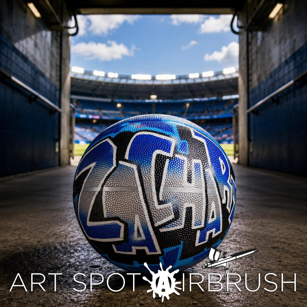 A basketball with the word "LA" painted on it, sitting on a wet surface in a stadium.