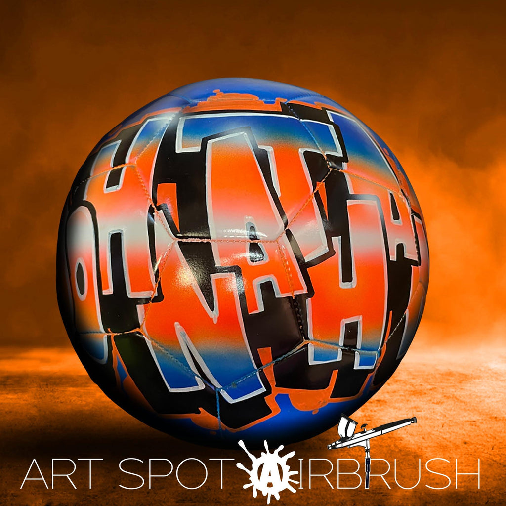 A colorful soccer ball with graffiti-style text on it, set against an orange and brown background.