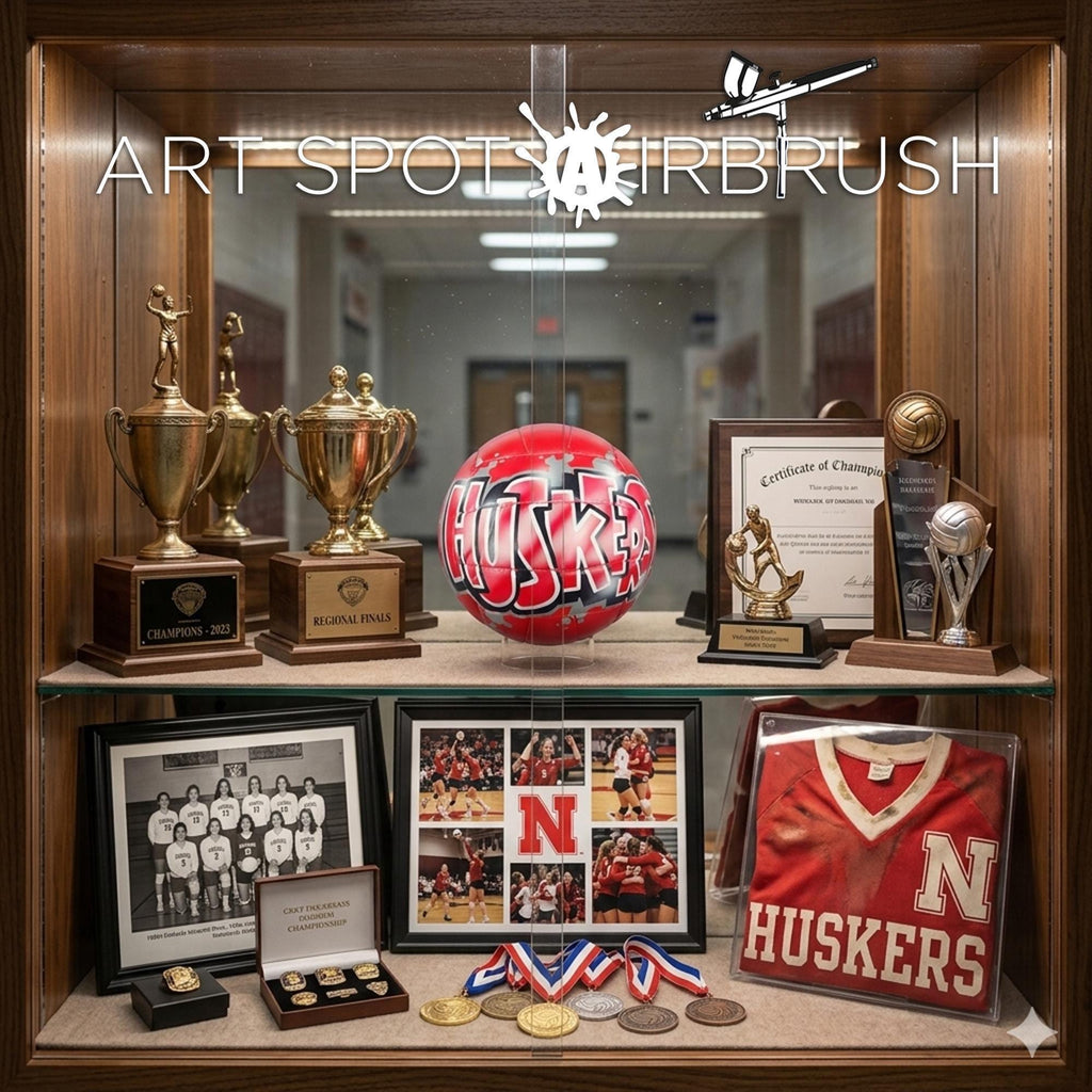 a collection of sports memorabilia and awards, including trophies, a basketball, and a framed jersey, arranged in a glass case.