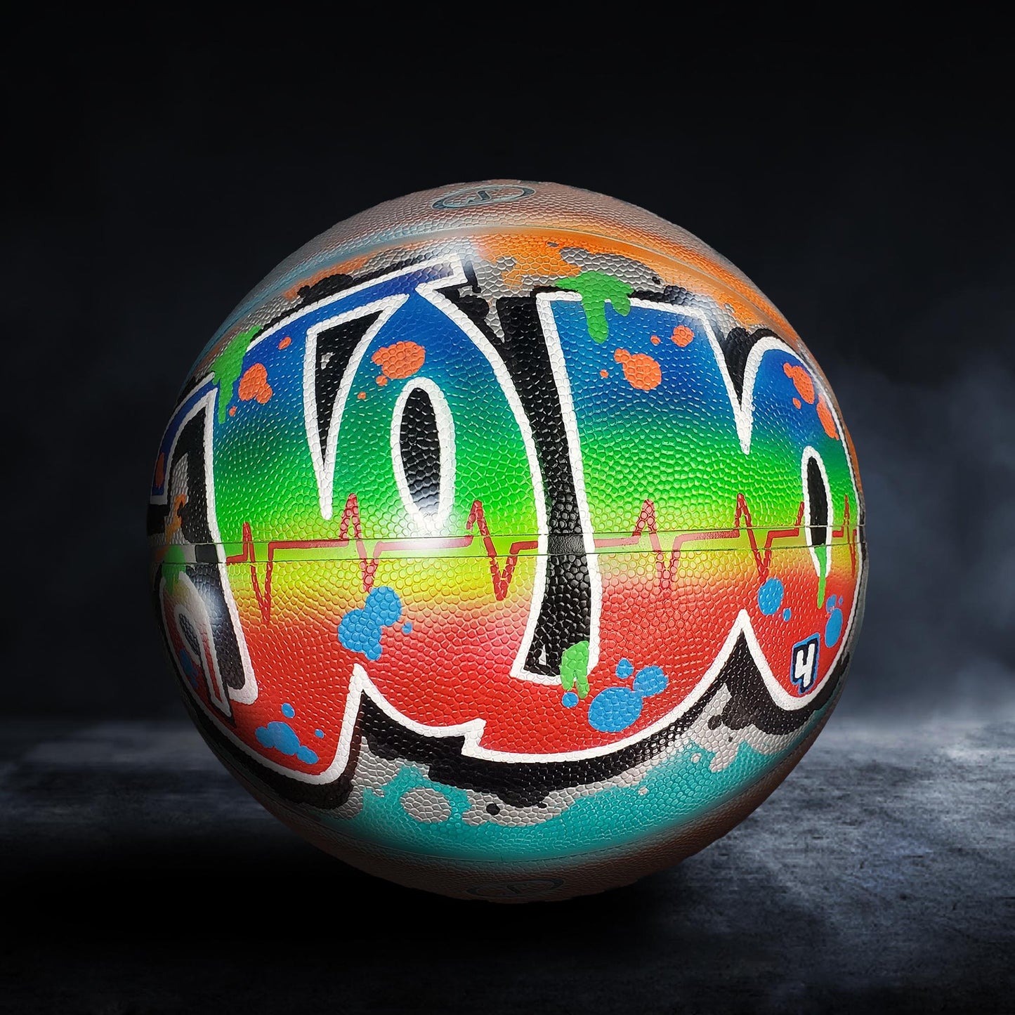 A colorful basketball with graffiti-style writing on it, including the word "YO" in various colors and designs.
