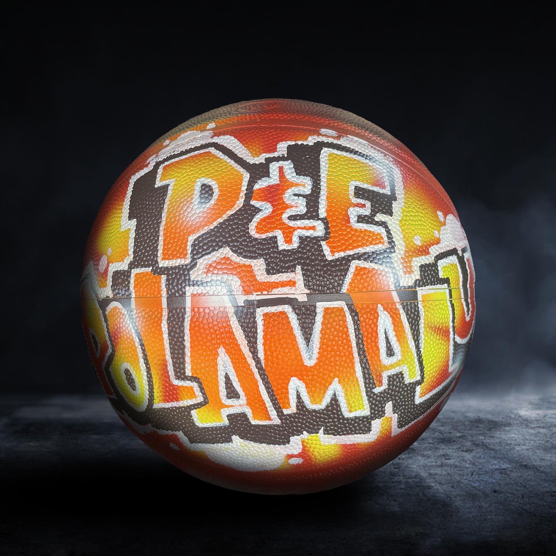 A basketball with graffiti text on it, including the words "PEE" and "AMAZING".