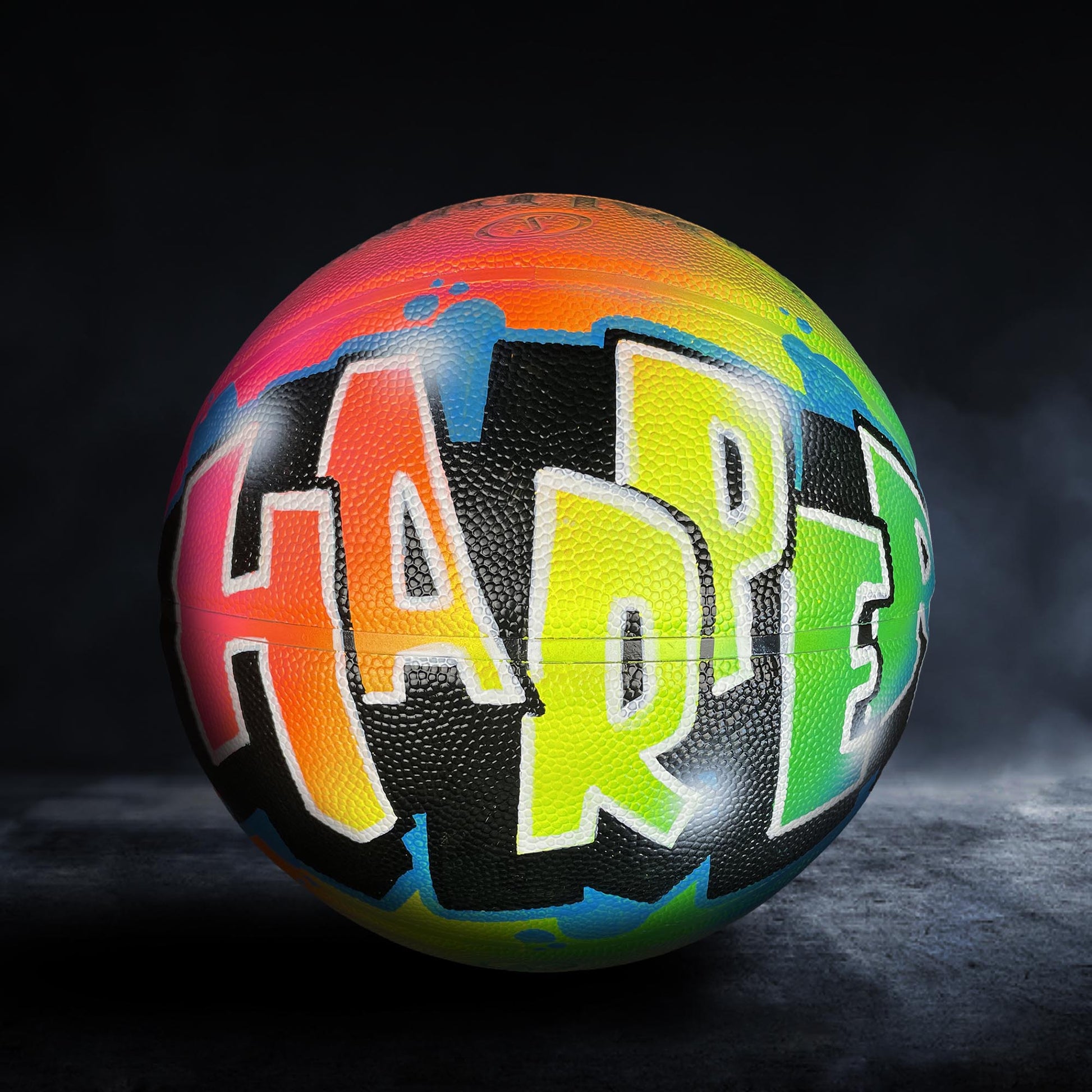 A colorful basketball with the word "HARPER" painted on it.