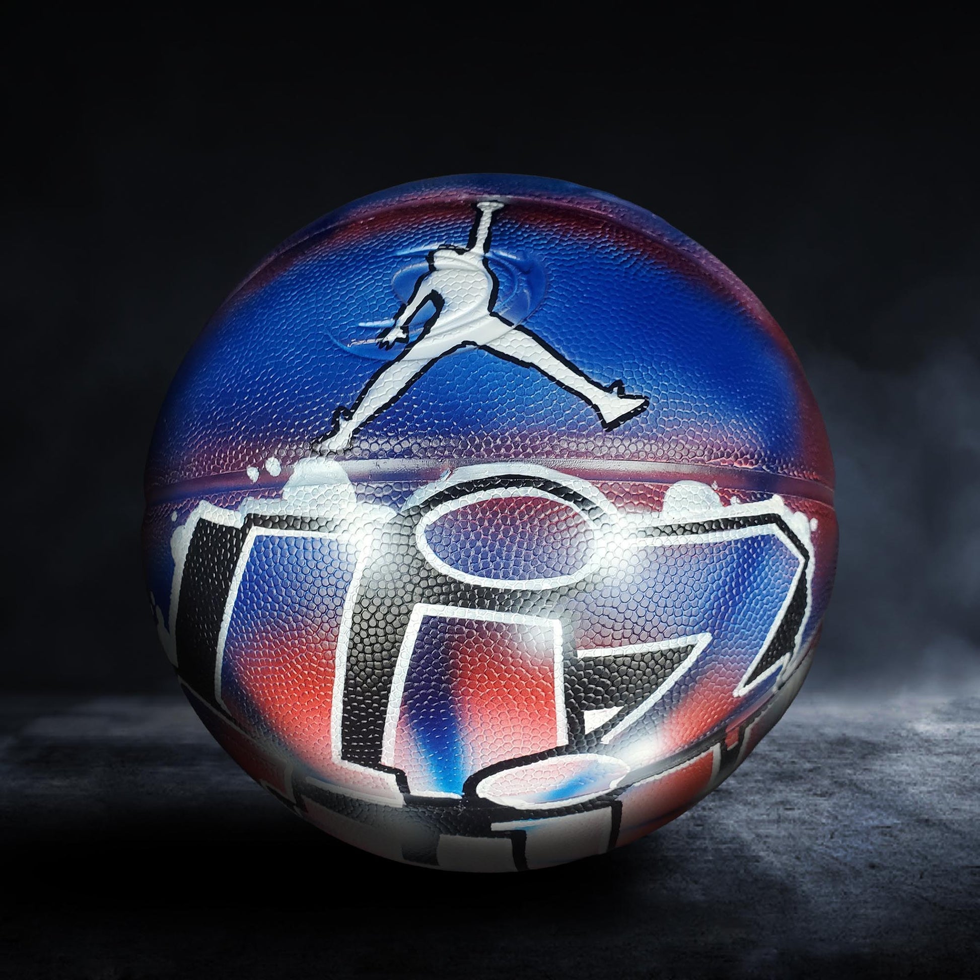 A basketball with a colorful, graffiti-style design on it, featuring a stylized figure and text.