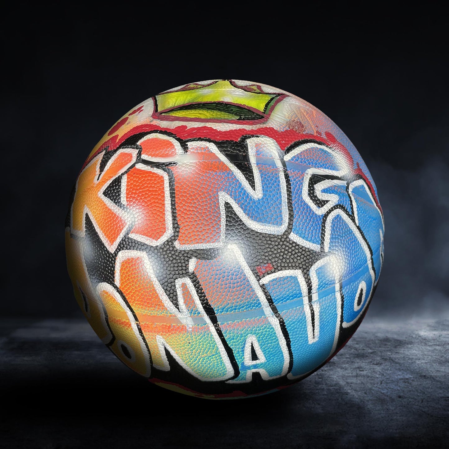 A colorful, graffiti-style basketball with the word "KING" written on it.