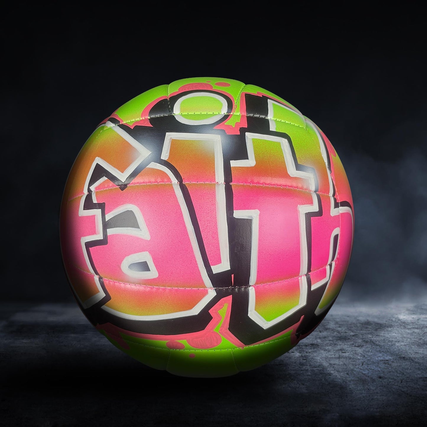 A colorful, graffiti-style soccer ball with the word "Faith" painted on it, set against a dark background.