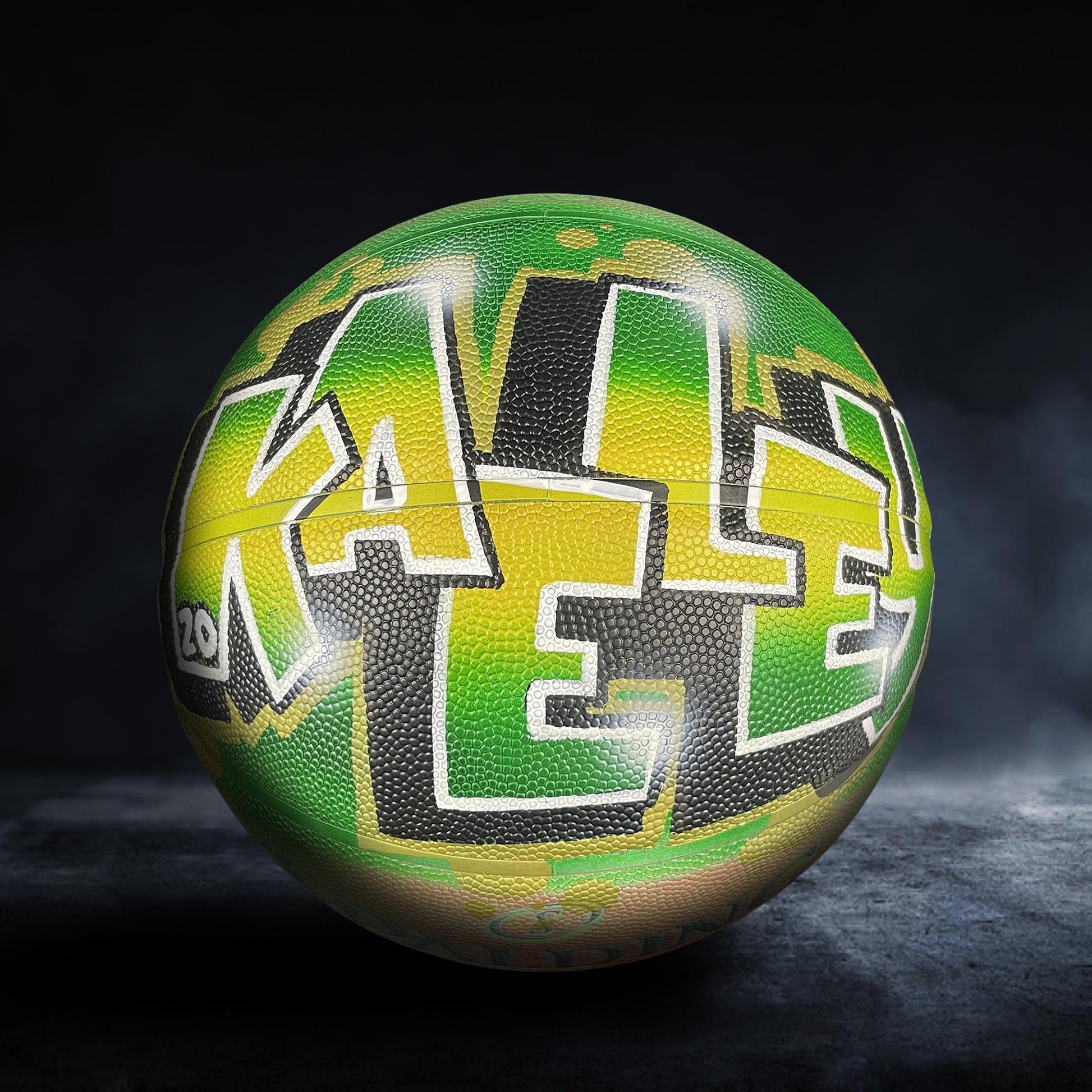 A basketball with the word "KALE" painted on it in a stylized, graffiti-like design.