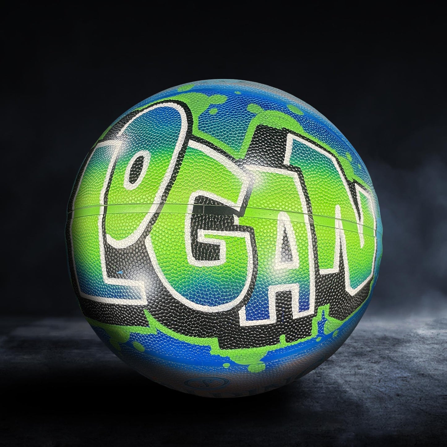 A basketball with the word "Logan" painted on it in a colorful, graffiti-style design.