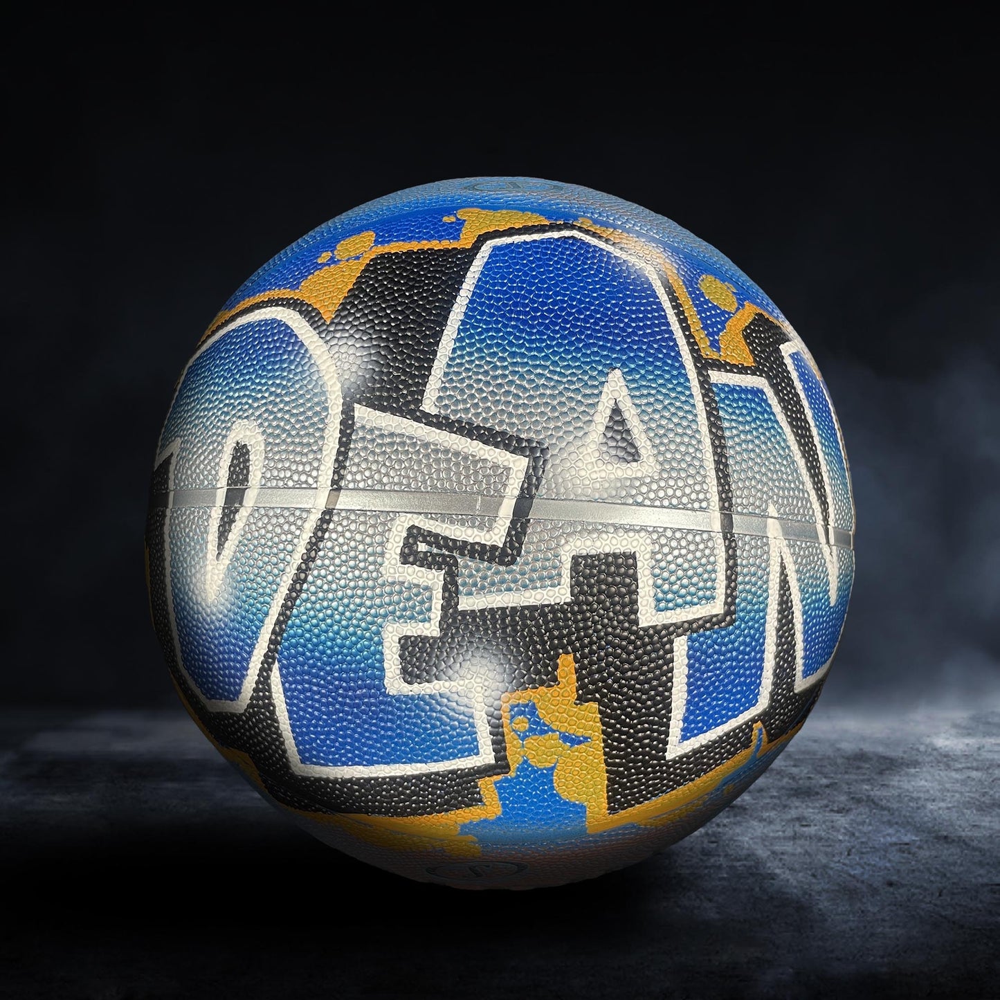 A basketball with the word "OCEAN" painted on it, featuring a colorful and abstract design.