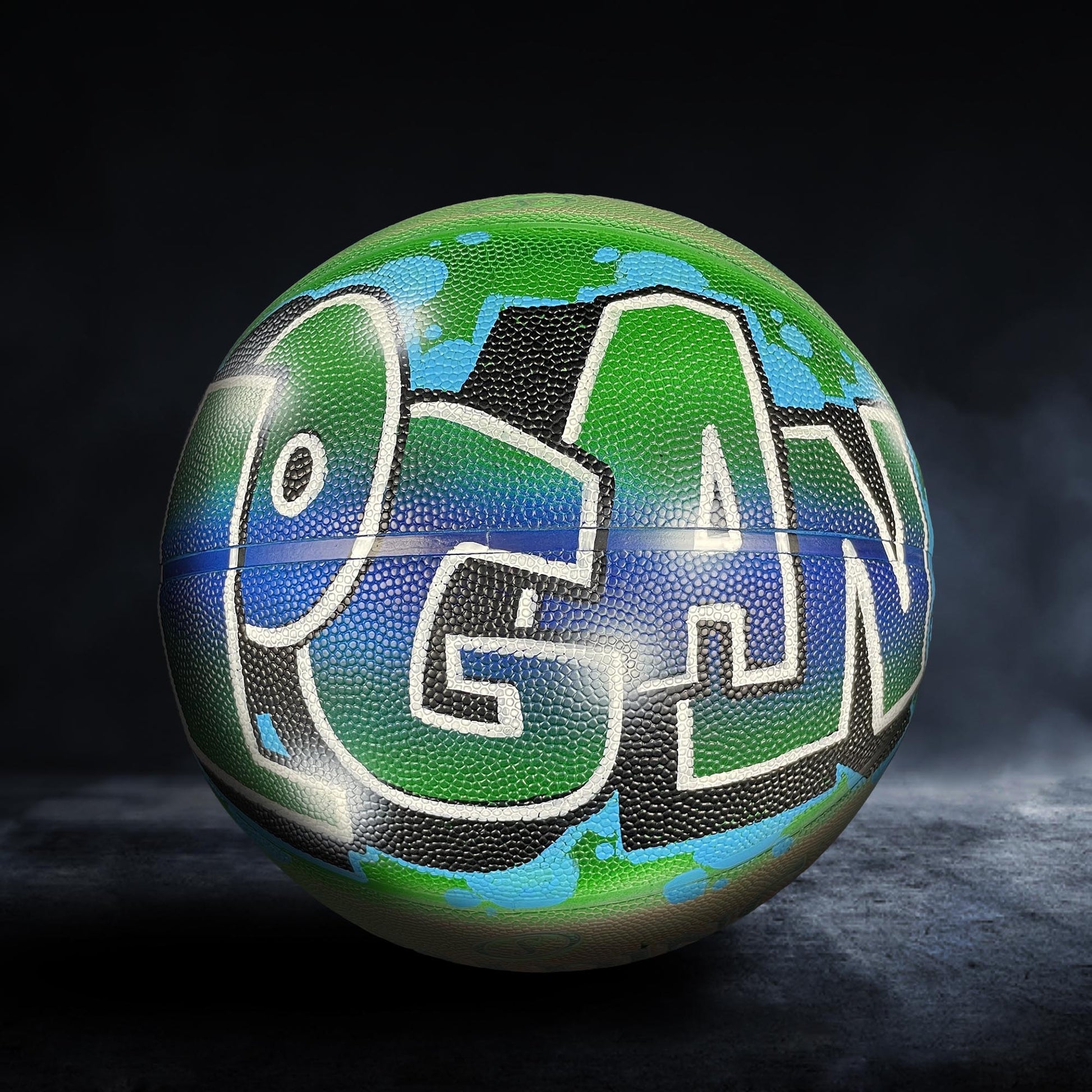 A basketball with the word "PAN" painted on it in a colorful, graffiti-style design.