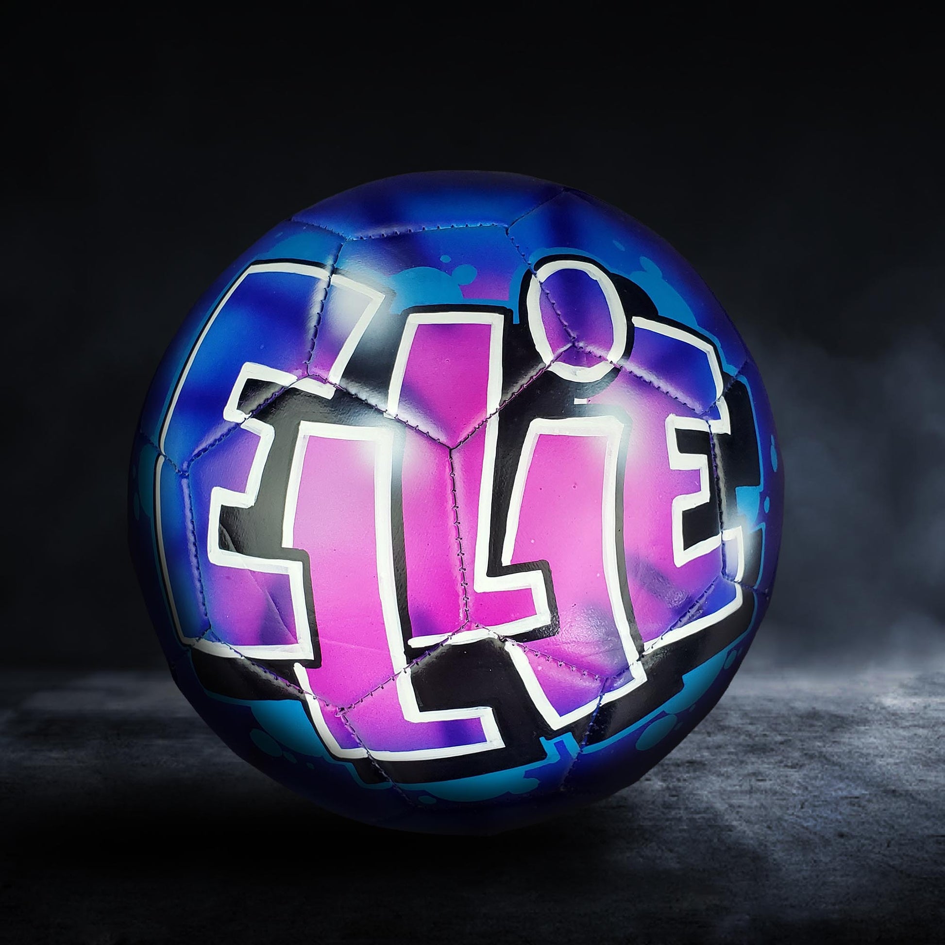 A soccer ball with the name "ELISE" painted on it in a colorful, graffiti-style design.