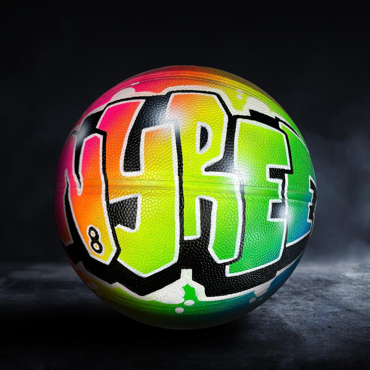 A colorful basketball with graffiti-style lettering on it.