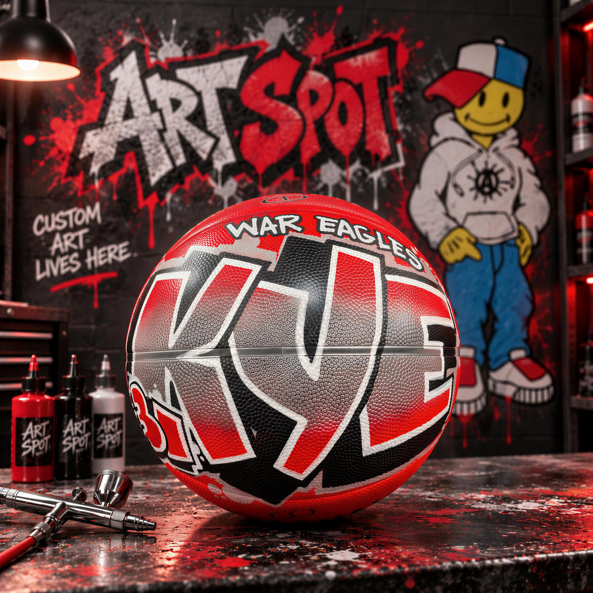 A basketball with the word "War Eagles" painted on it, sitting on a table in front of a graffiti-covered wall.