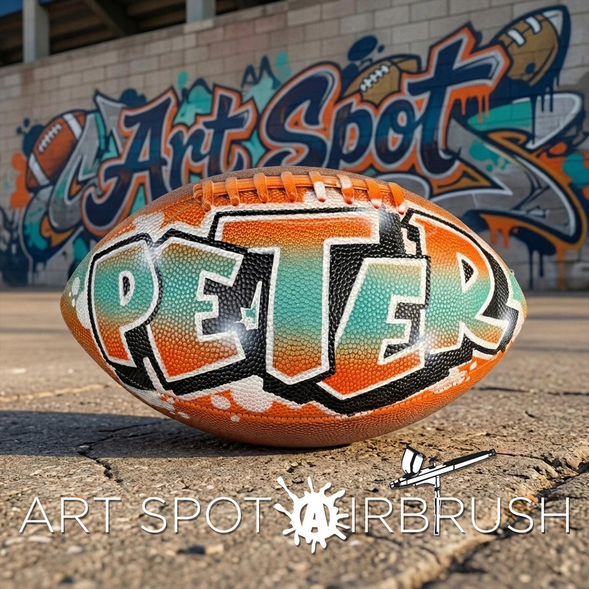 A personalized football with the name "PETER" painted on it, placed on a concrete surface in front of a graffiti-covered wall.