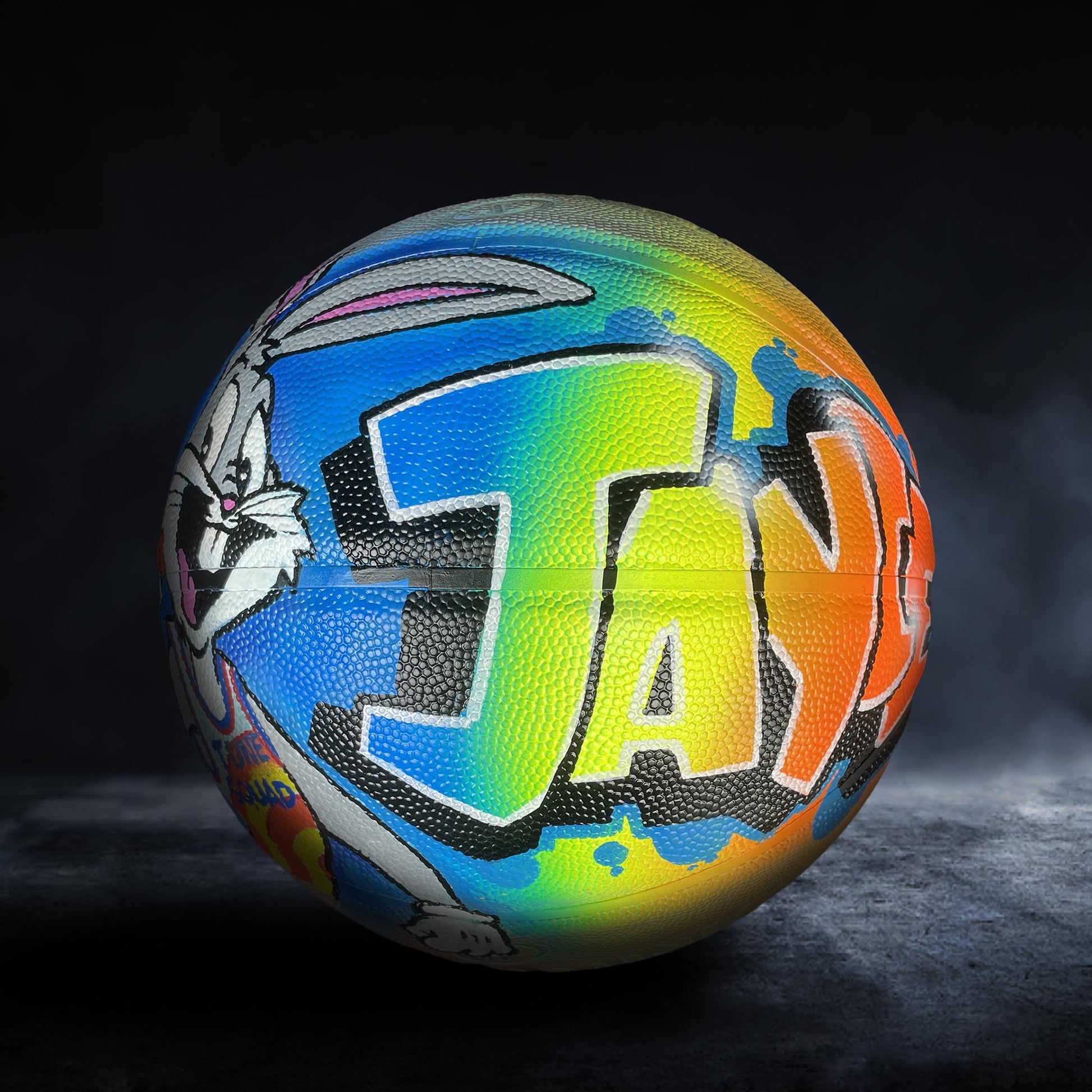 A colorful basketball with the word "JAY" painted on it, featuring a cartoon character design.