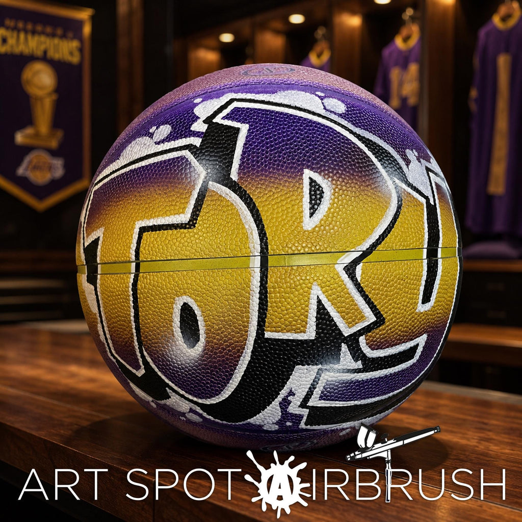 A basketball with the word "TORY" painted on it, sitting on a wooden surface.