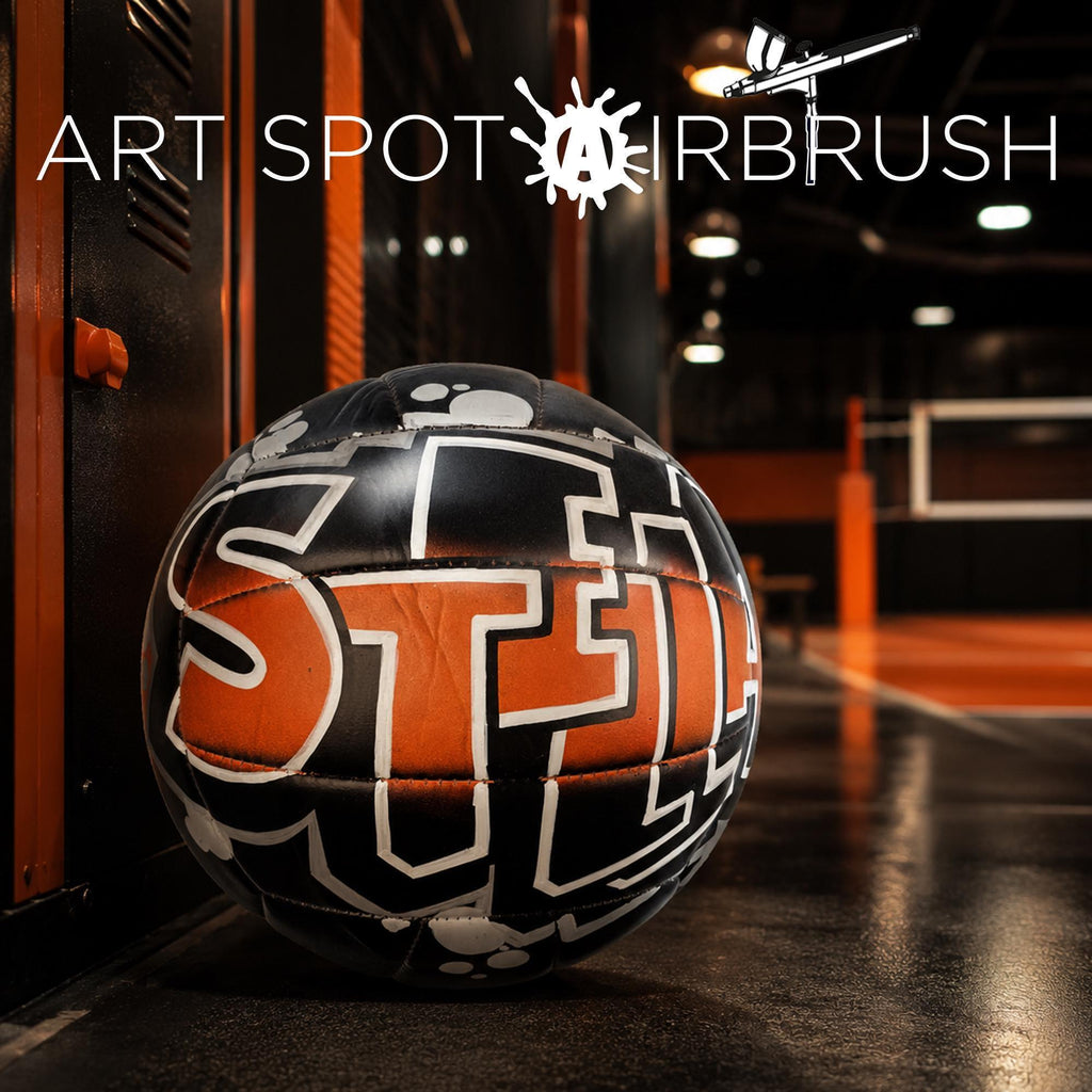 A custom volleyball with the word "Stella" written on it, placed on a surface in an indoor setting.