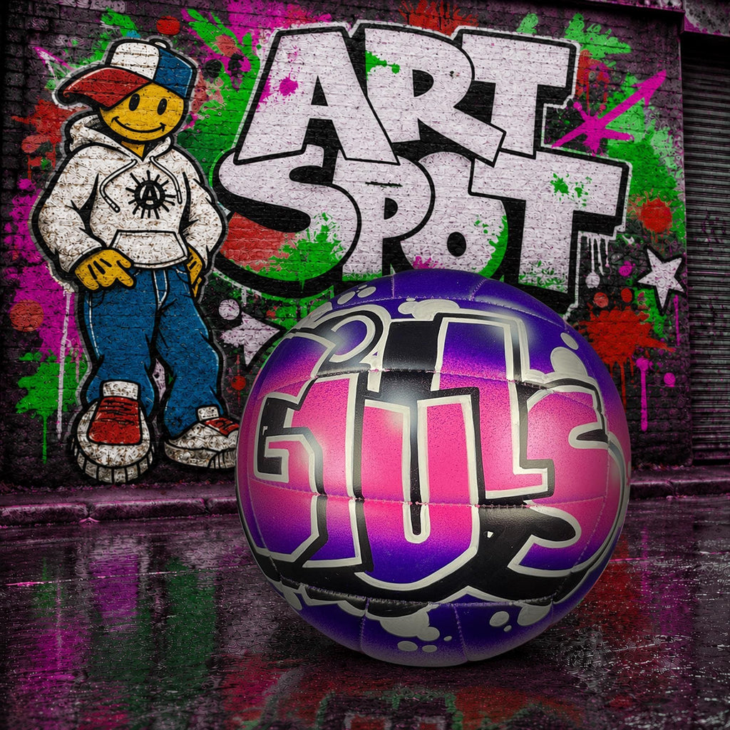 A colorful graffiti-style wall with a cartoon character AND ART SPOT in graffiti. A custom volleyball with the word "GIULS" written on it, placed in front of the graffiti.