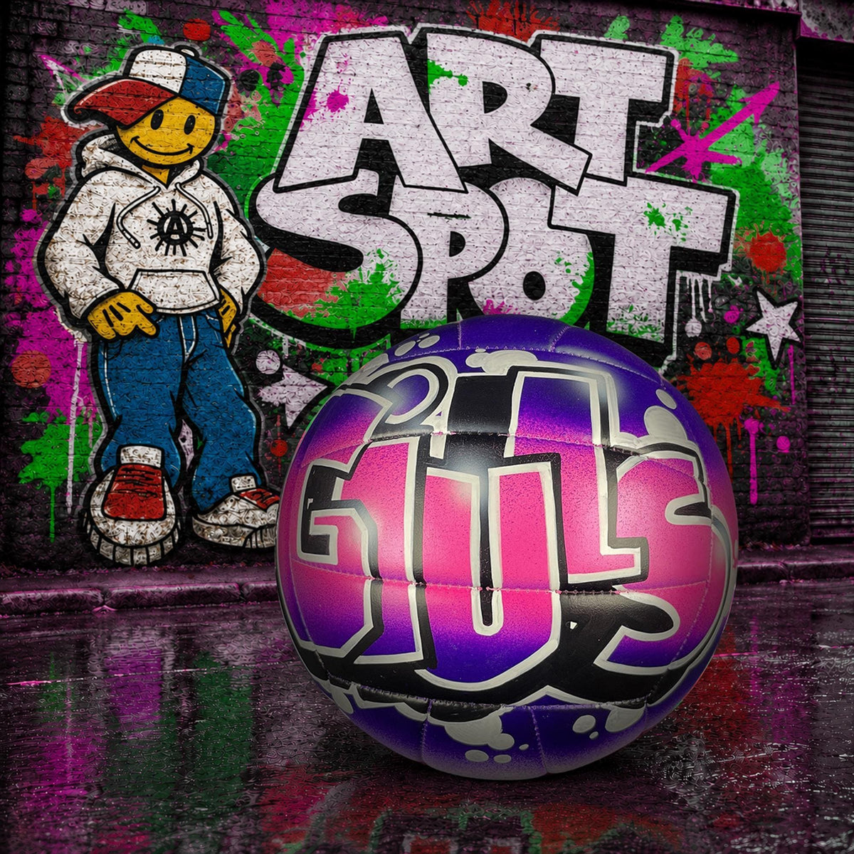 A colorful graffiti-style wall with a cartoon character AND ART SPOT in graffiti. A custom volleyball with the word "GIULS" written on it, placed in front of the graffiti.