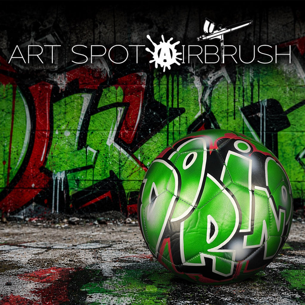 a green soccer ball with the word "DMB" painted on it, set against a backdrop of graffiti on a wall.