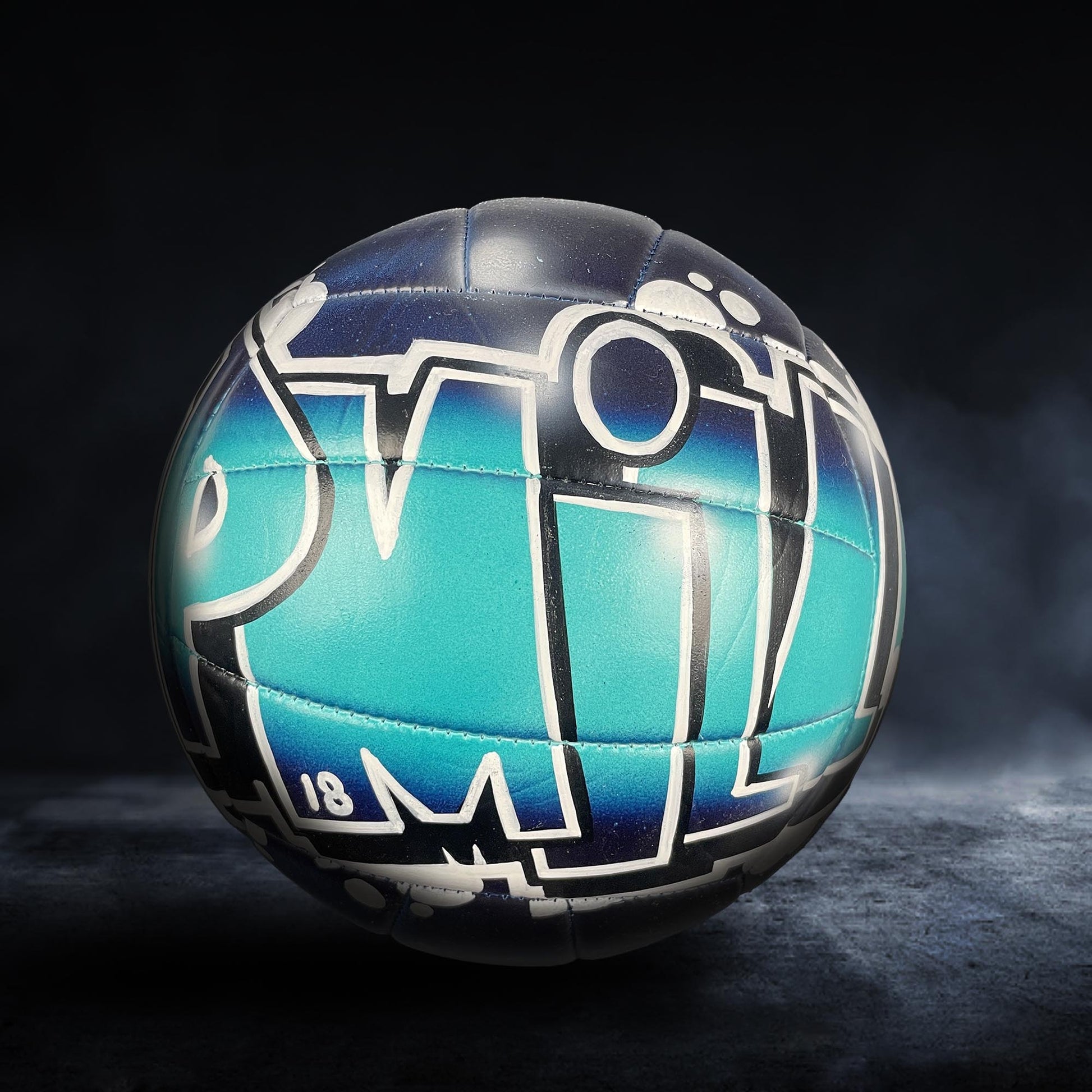 A soccer ball with a colorful, graffiti-style design on it, featuring the letters "PM" in a stylized font.