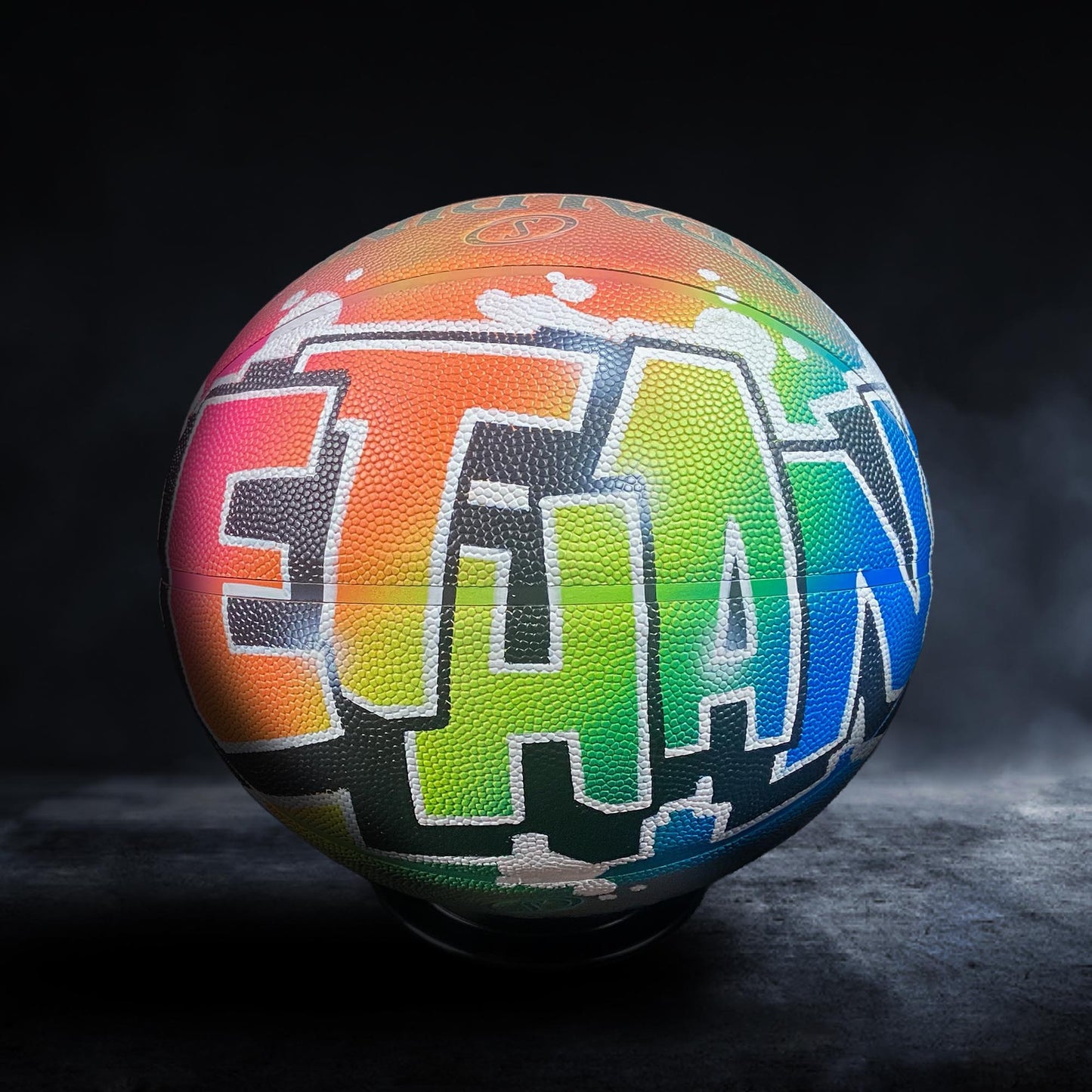 A basketball with a colorful, graffiti-style design on it, featuring the word "Ethan" prominently displayed.