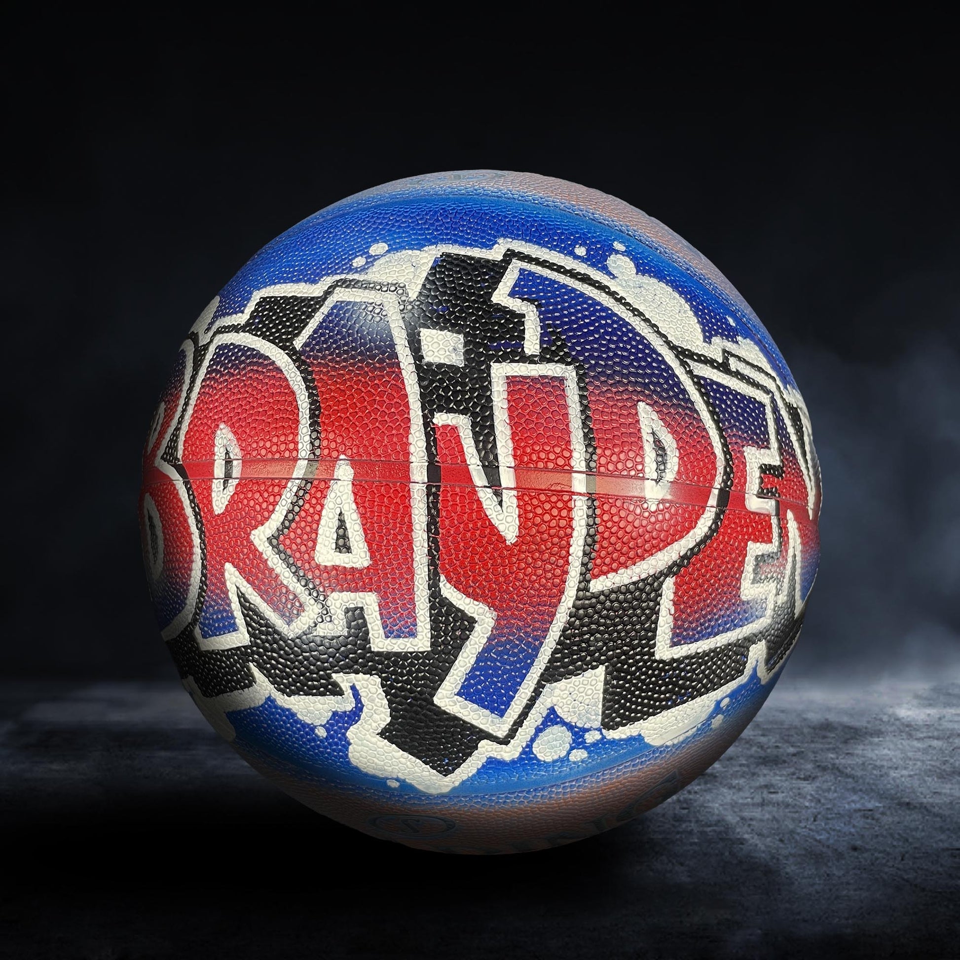 A basketball with the word "BRADIE" painted on it in a stylized, graffiti-like design.